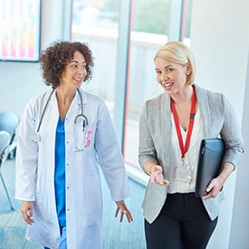 Doctor walking and talking with Healthcare manager.