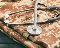 Stethoscope on top of a folded military uniform.