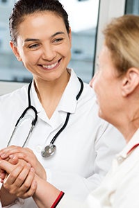 Doctor holding hands with elderly patient.